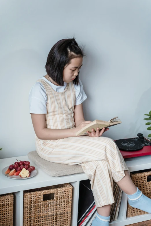 a little girl sitting on a bench reading a book, inspired by Ruth Jên, trending on pexels, happening, books on side table, cookbook photo, teenage female schoolgirl, cinematic outfit photo