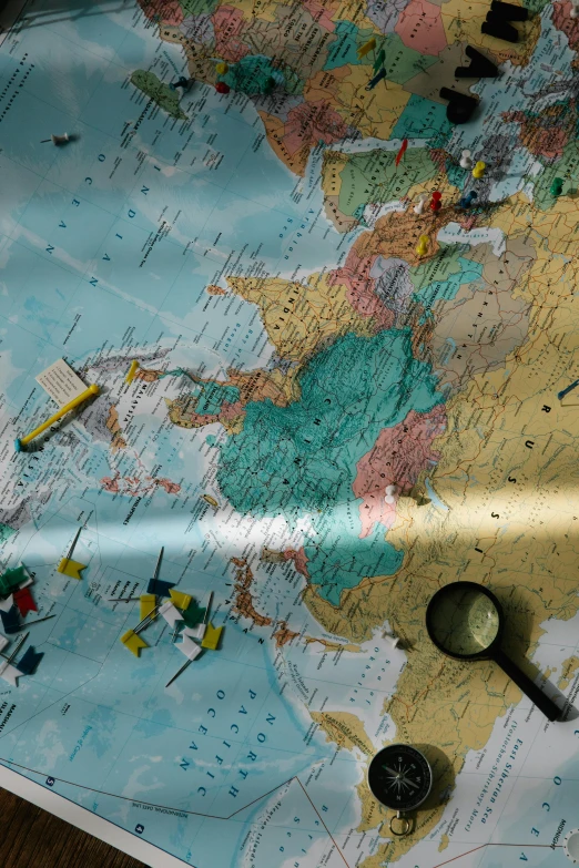 a close up of a map on a table, a jigsaw puzzle, magnifying glass, in 2 0 1 2, turbulence, continents