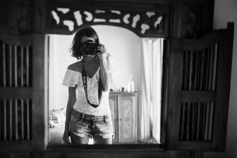 a woman taking a picture of herself in a mirror, a black and white photo, art photography, croptop and shorts, medium format, white lace clothing, :: morning