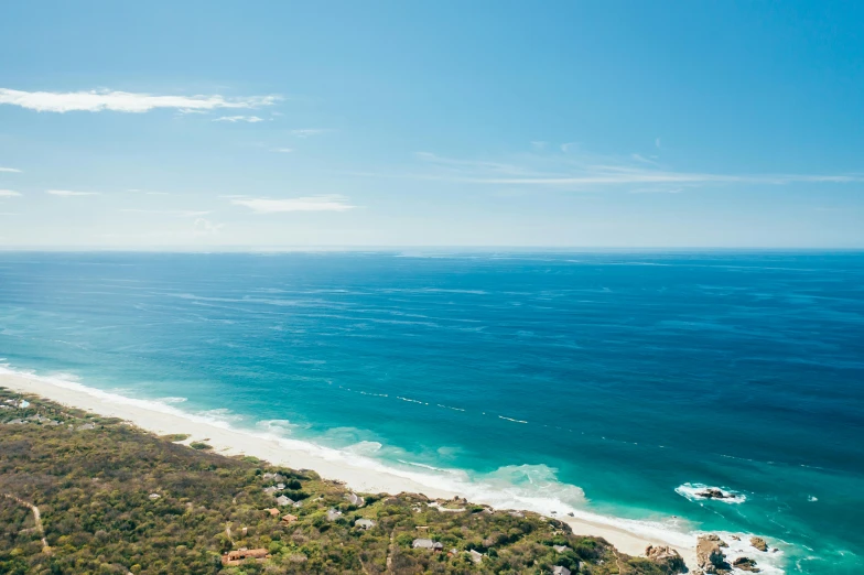 a view of the ocean from the top of a hill, australian beach, conde nast traveler photo, helicopter view, blue