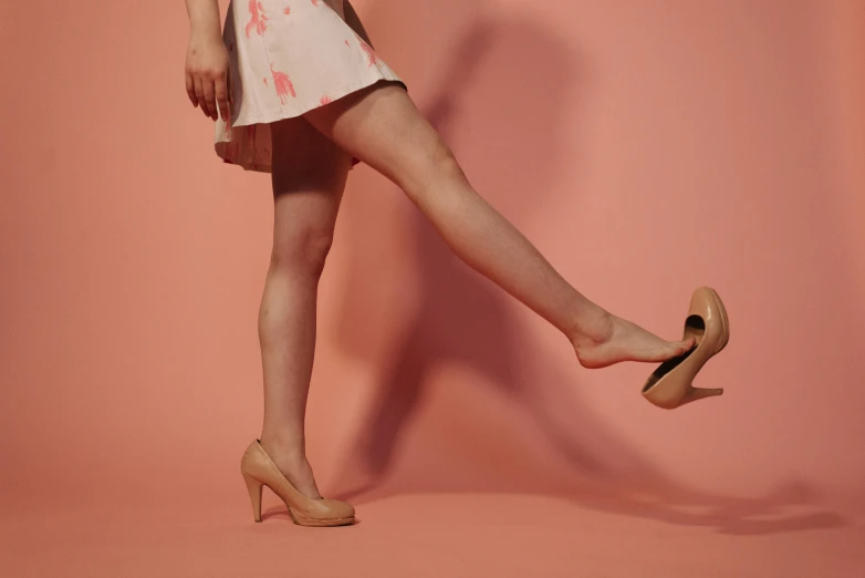 a woman in a dress and high heels on a pink background, inspired by Balthus, trending on pexels, figuration libre, dynamic low angle shot, light tan, alessio albi, human legs