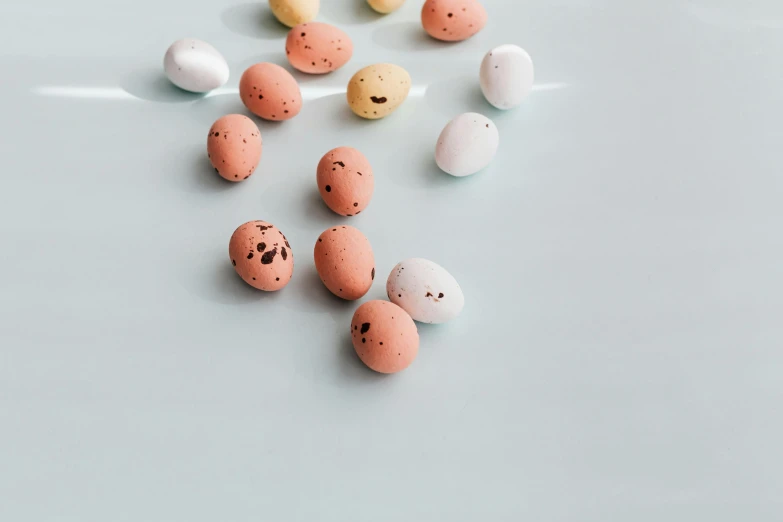 a bunch of eggs sitting on top of a table, an album cover, trending on pexels, background image, marshmallow, micro expressions, beans