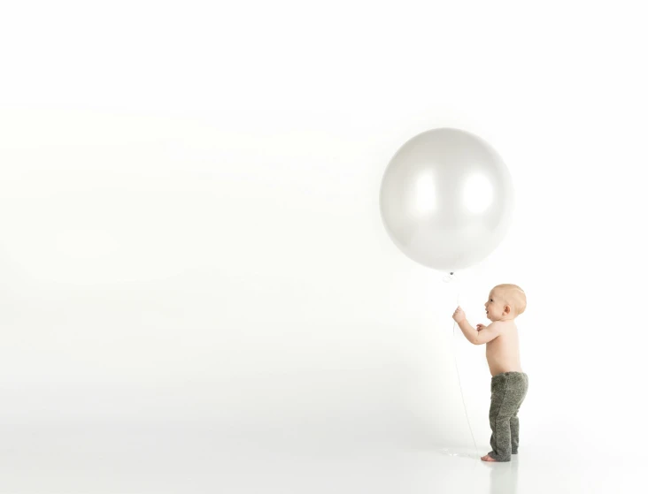 a small child is holding a white balloon, pexels contest winner, made out of shiny silver, white backdrop, enormous scale, thumbnail