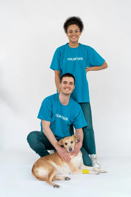 a man and a woman pose for a picture with a dog, by Gavin Hamilton, official product photo, teal uniform, adoptables, in white lettering