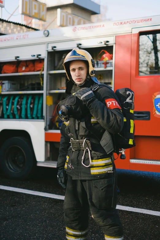 a firefighter standing in front of a fire truck, a picture, by Adam Marczyński, renaissance, genderless, technical suit, black, gen z