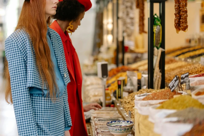 a couple of women standing next to each other at a market, trending on pexels, visual art, gucci bread, sadie sink, red blue and gold color scheme, inspect in inventory image