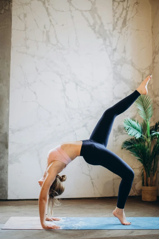 a woman doing a handstand pose on a yoga mat, pexels contest winner, arabesque, all marble, arched back, low quality photo, archs