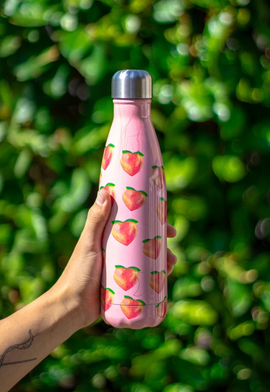 a person holding a pink water bottle with peachs on it, by Julia Pishtar, emma bridgewater and paperchase, angled shot, 2 5 6 x 2 5 6 pixels, peaches