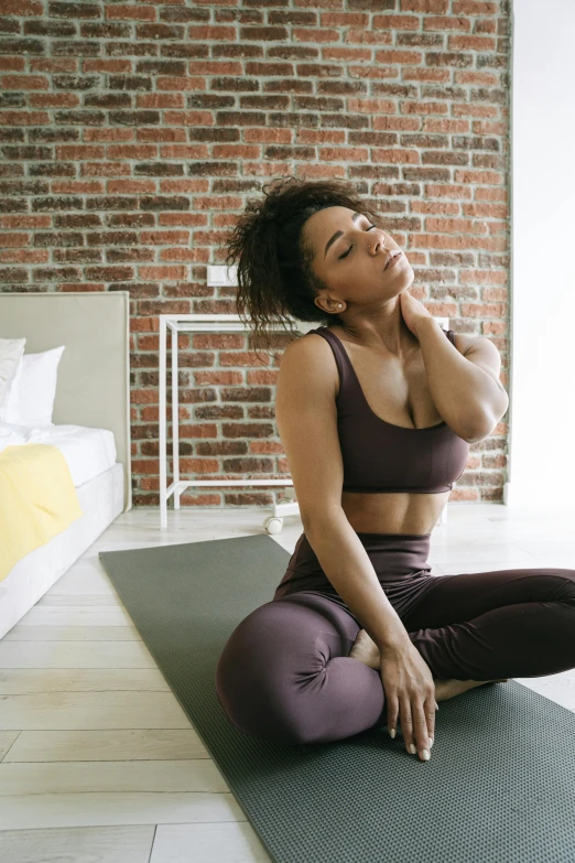 a woman sitting on a yoga mat in a bedroom, trending on pexels, renaissance, muscular neck, stressing out, tight around neck, garnet