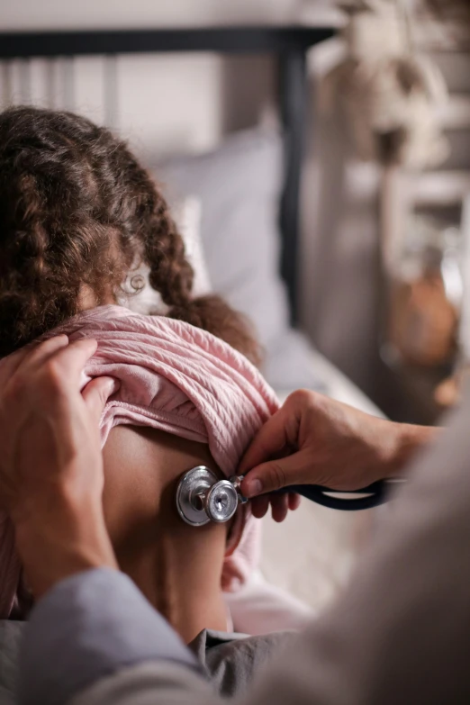 a doctor examining a child's chest with a stethoscope, a picture, pexels contest winner, renaissance, showing her shoulder from back, black haired girl wearing hoodie, thumbnail, documentary still