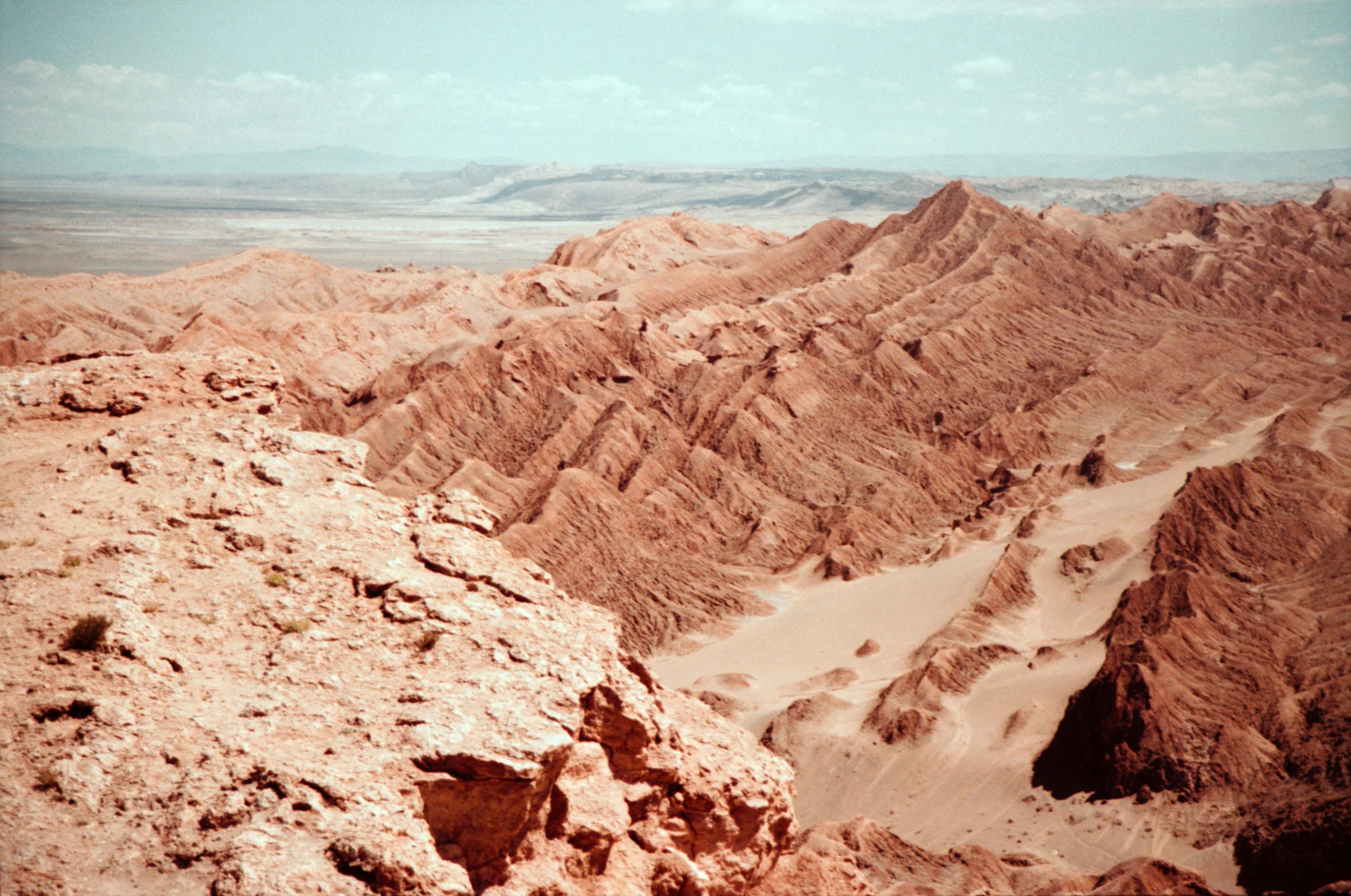 a view of the desert from the top of a mountain, a colorized photo, by Andrei Kolkoutine, trending on unsplash, in a dusty red desert, 1960s color photograph, erosion, andes