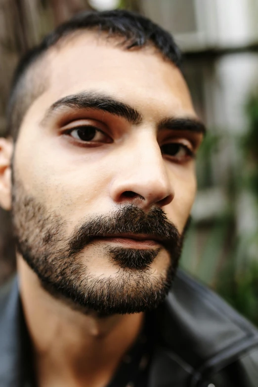 a close up of a man wearing a leather jacket, by Edward Avedisian, he got a big french musctache, a portrait of rahul kohli, nonbinary model, taken in the late 2010s