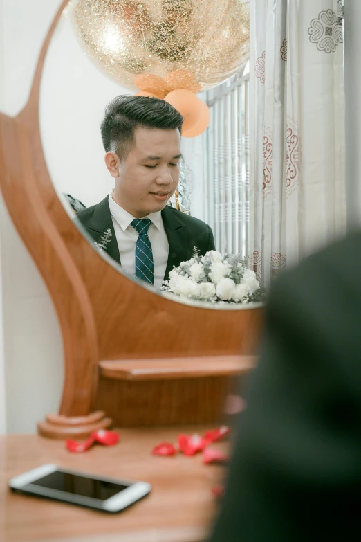 a man in a suit looking at himself in a mirror, inspired by Ruth Jên, ao dai, wearing a wedding dress, he is about 20 years old | short, ceremonial