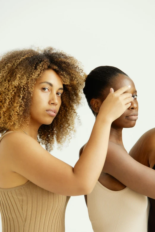 a couple of women standing next to each other, by Carey Morris, trending on pexels, renaissance, brown skin. light makeup, hands shielding face, set against a white background, hair covering eyes