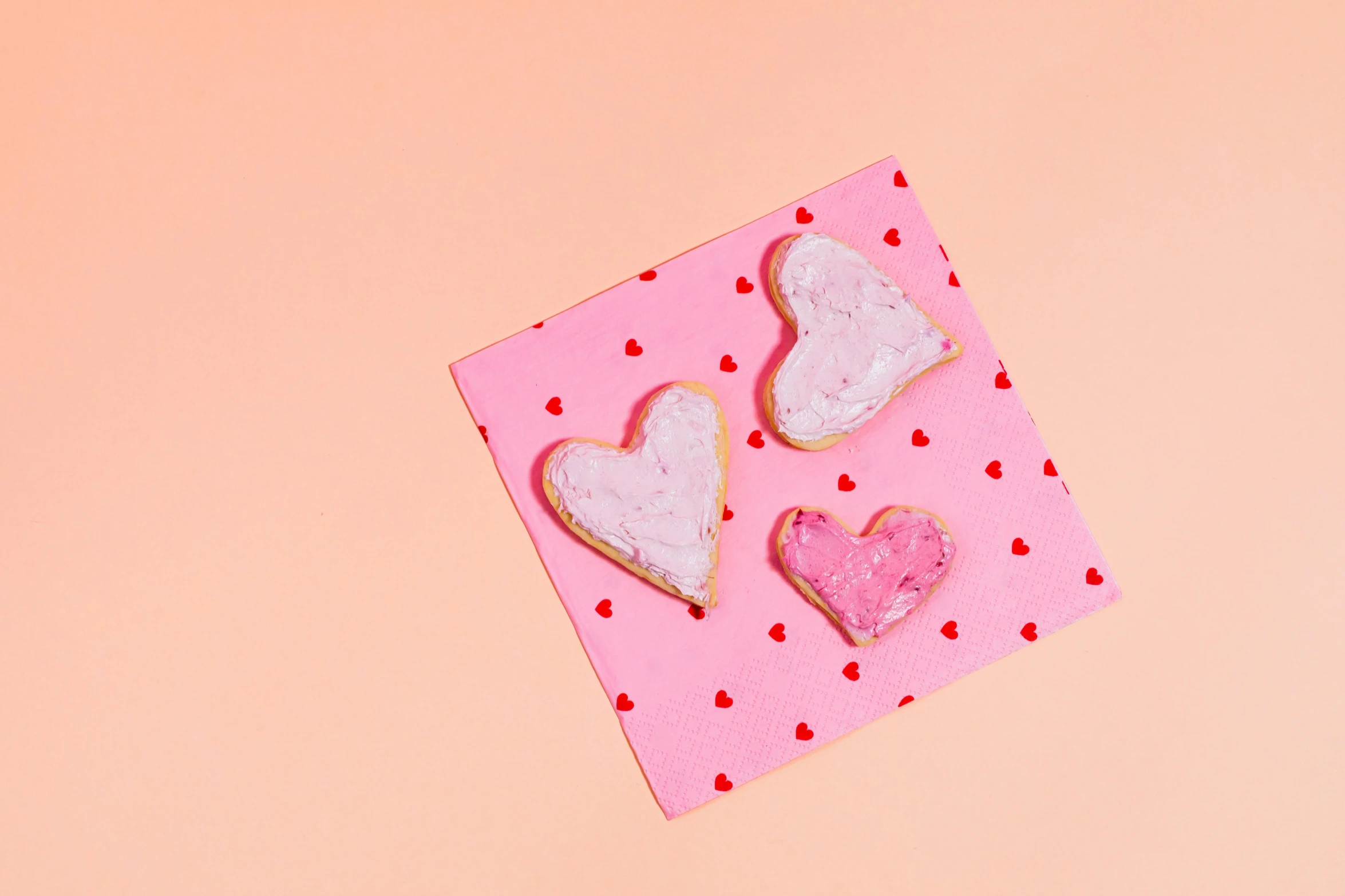 a couple of heart shaped cookies sitting on top of a pink piece of paper, trending on pexels, background image, thumbnail, 3 1, various posed