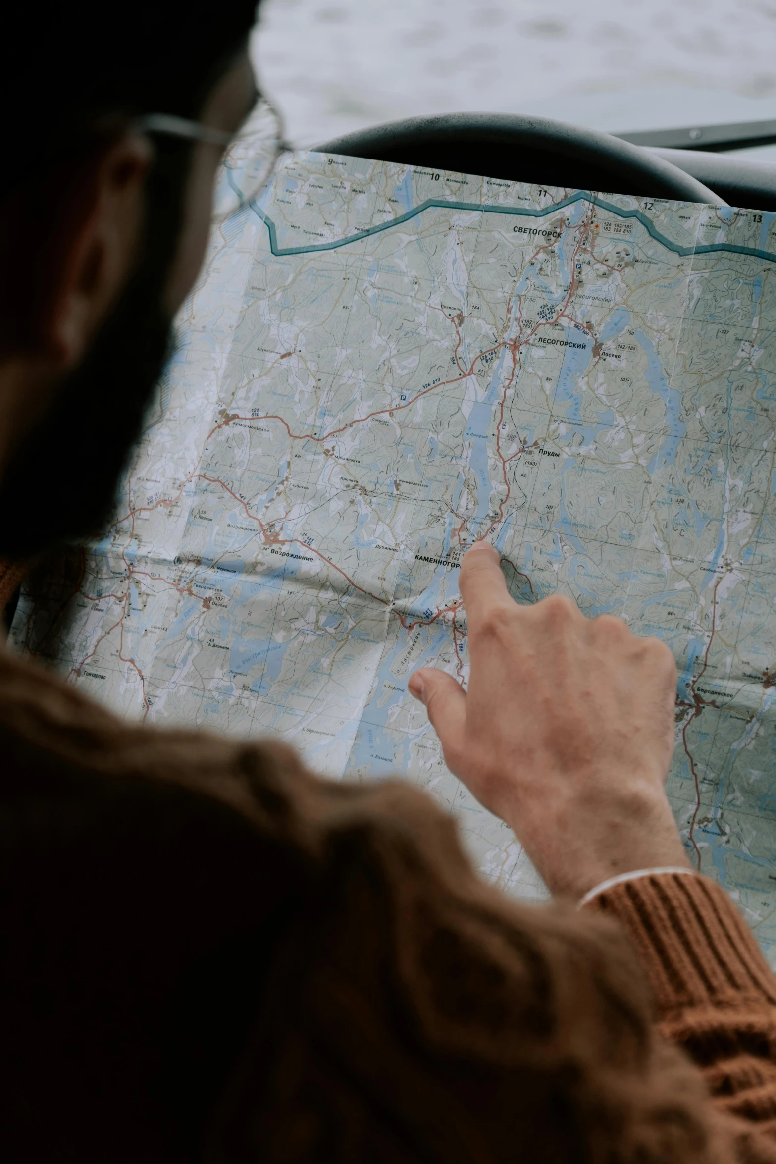 a man sitting in a car looking at a map, by Jaakko Mattila, pexels, screenshot from a movie, high angle close up shot, instagram post, plan
