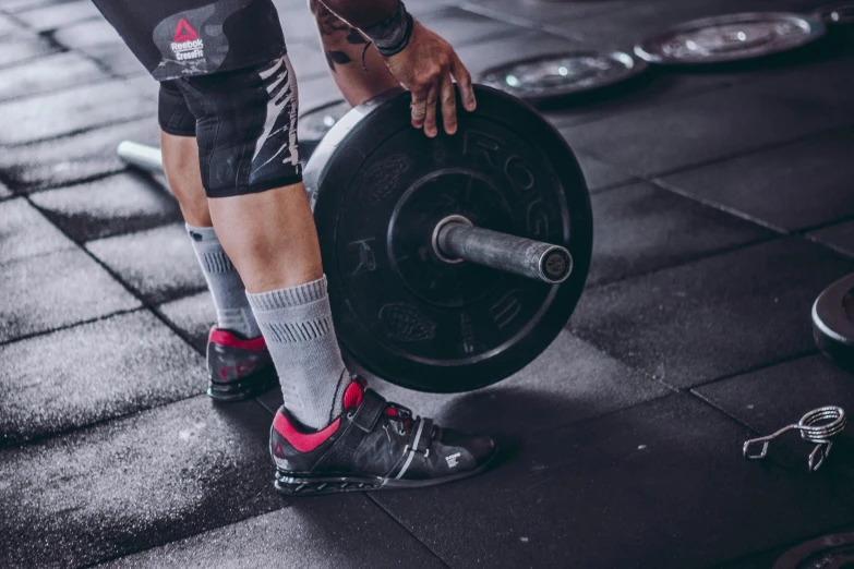 a close up of a person holding a barbell, gray shorts and black socks, “ iron bark, avatar image, high quality upload