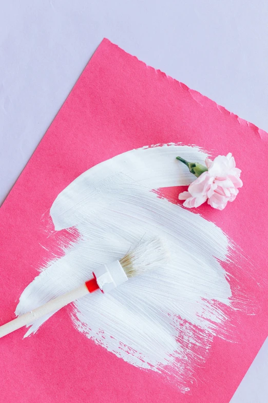 a close up of a piece of paper with a flower on it, a silk screen, paint brush strokes, pink background, white color scheme, red and white color theme