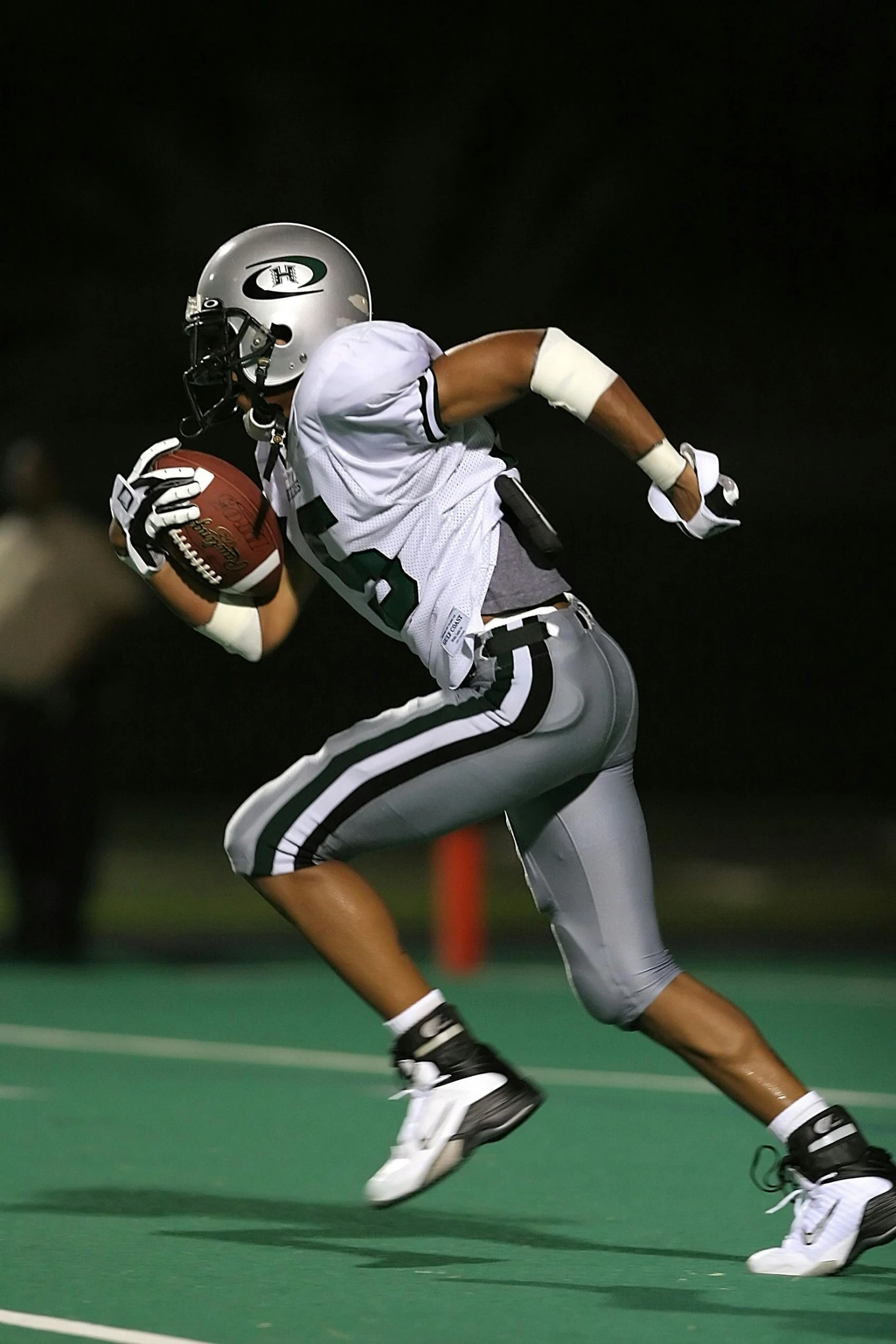 a football player running with the ball, by Ben Zoeller, slide show, green and white, grey, (night)