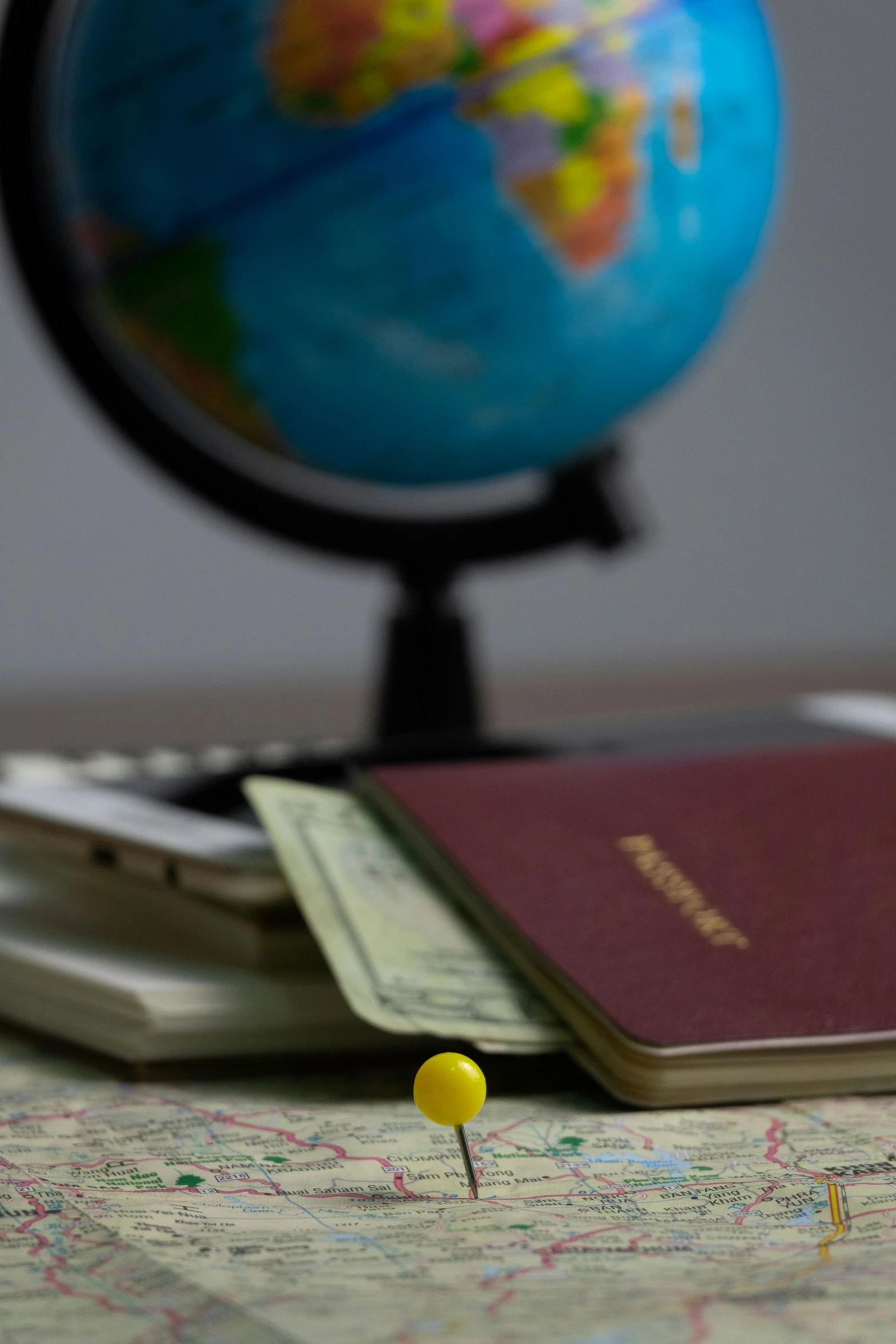 a passport sitting on top of a map next to a globe, yellow, thumbnail, cash, mini model