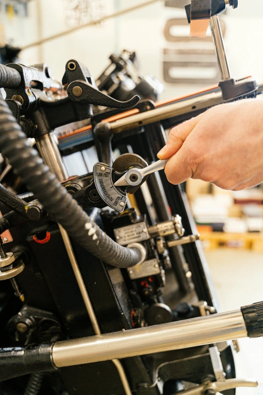 a close up of a person working on a motorcycle, private press, giant mechanisms, thumbnail, workshop, brown