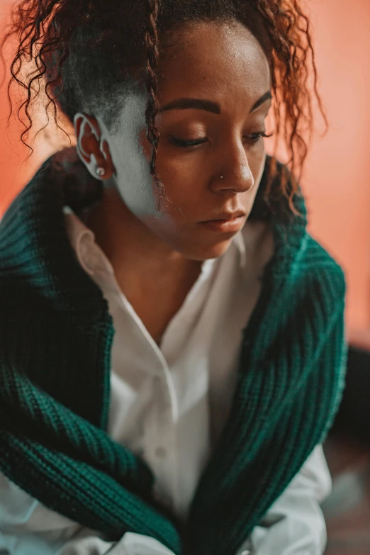 a woman sitting on the floor with her eyes closed, inspired by Elsa Bleda, trending on pexels, renaissance, photo of a black woman, wearing a green sweater, beautiful crying! android woman, wearing a white button up shirt