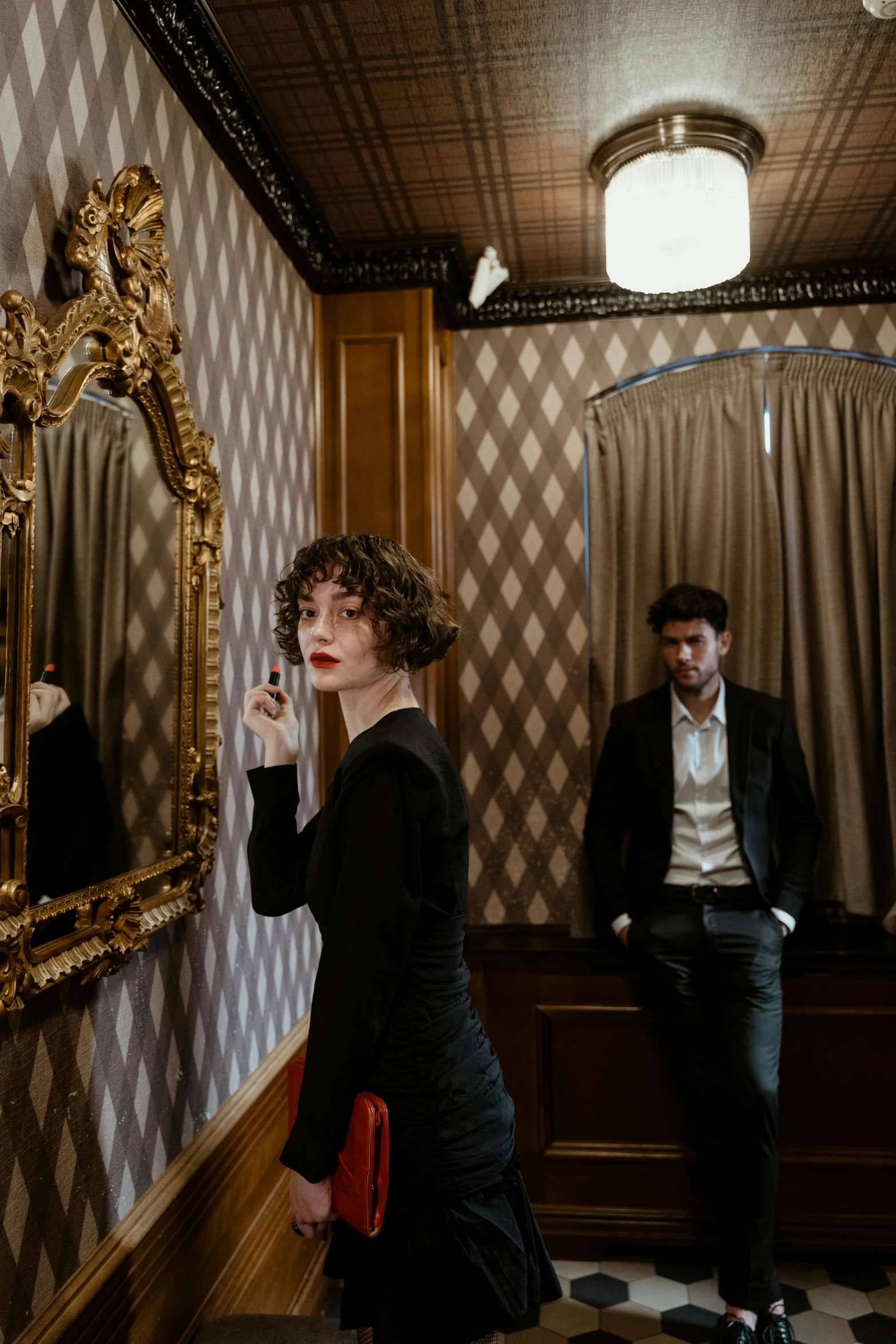 a man and a woman standing in front of a mirror, inspired by Nan Goldin, renaissance, paris hotel style, 1 9 2 0 s room, finn wolfhard, promotional image