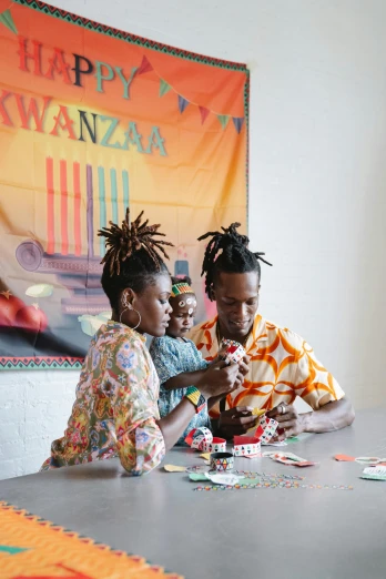 a group of people sitting around a table playing a game, by Dan Frazier, black arts movement, short dreadlocks with beads, okuda, press photos, family