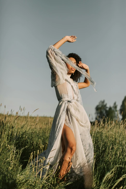 a woman in a white dress standing in a field, unsplash, renaissance, wearing silver silk robe, playful pose of a dancer, at a fashion shoot, instagram photo