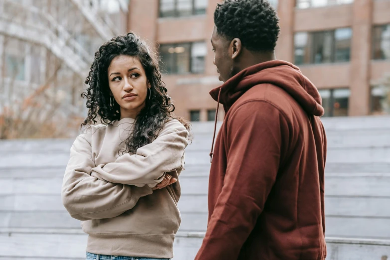 a man and a woman standing next to each other, trending on pexels, bullying, he is wearing a brown sweater, mixed race, prompt young woman