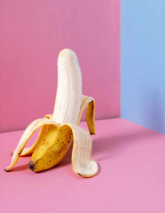 a peeled banana sitting on top of a pink and blue surface, trending on unsplash, hyperrealism, in a strip club, lascivious pose, 🐿🍸🍋