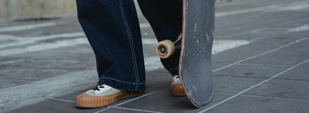 a person standing next to a skateboard on a sidewalk, pexels contest winner, hyperrealism, denim, corduroy, 15081959 21121991 01012000 4k, low detail