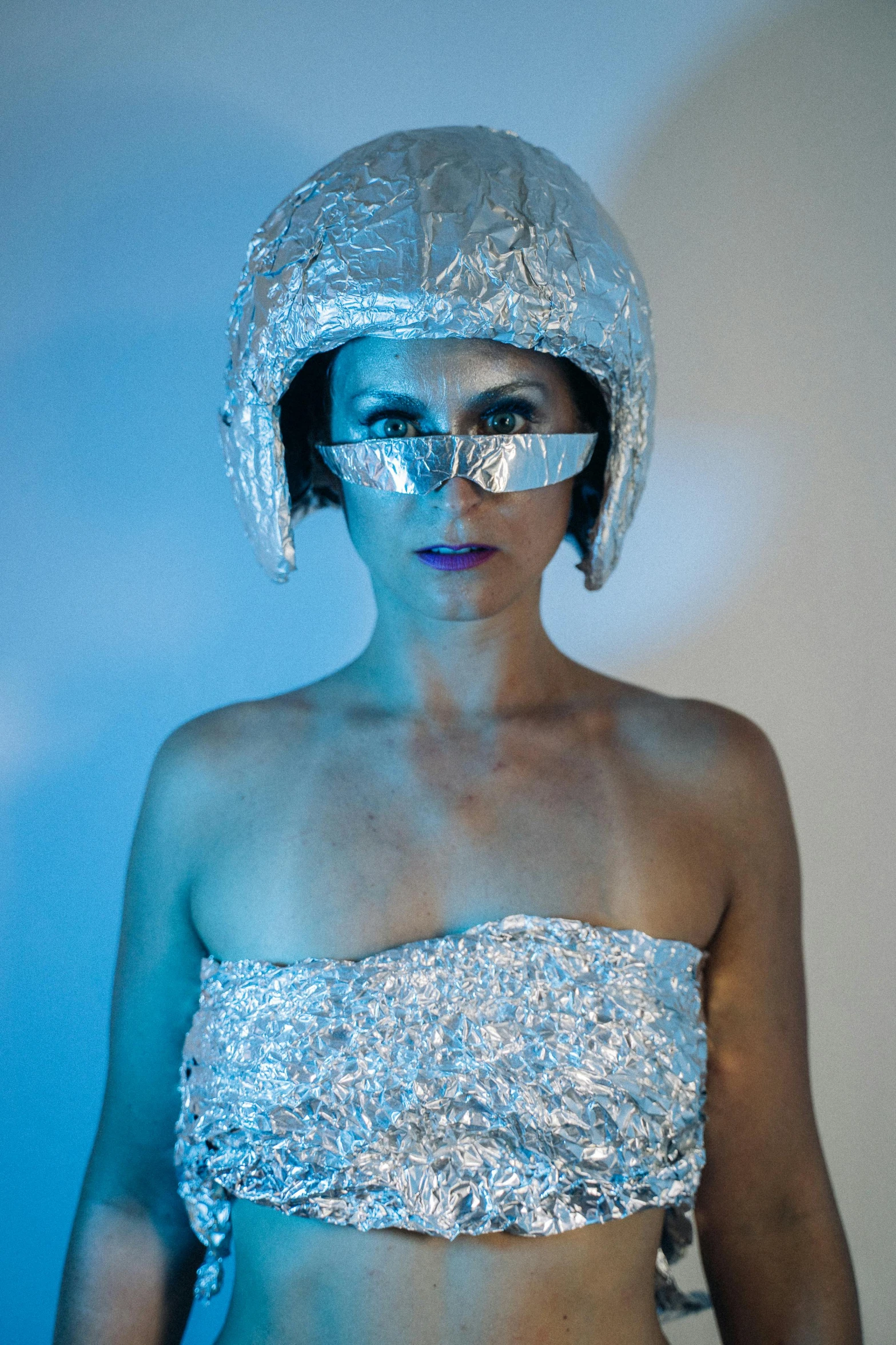 a woman in silver is posing for a picture, inspired by hajime sorayama, unsplash, holography, eyes projected onto visor, wearing an astronaut helmet, short blue haired woman, wearing a dress made of stars