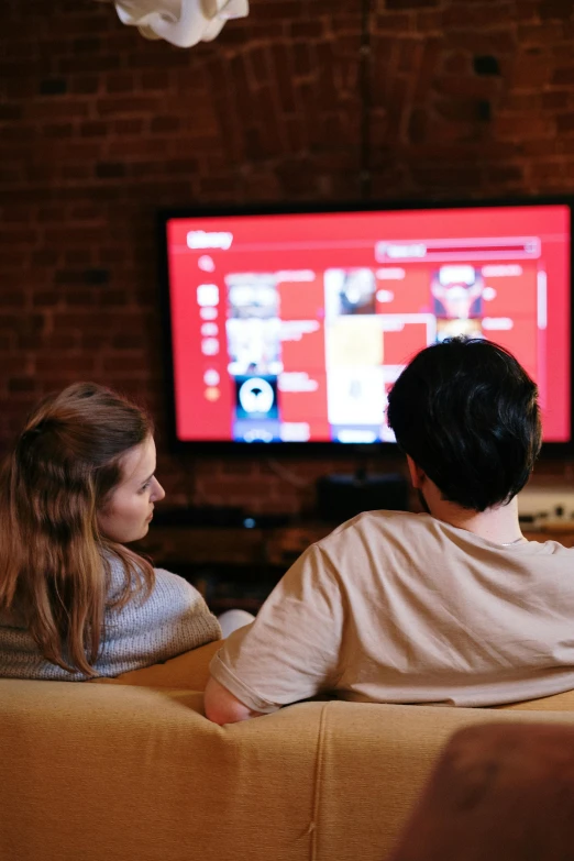 a couple of people sitting on a couch in front of a tv, pexels, square, internet, screensaver, university