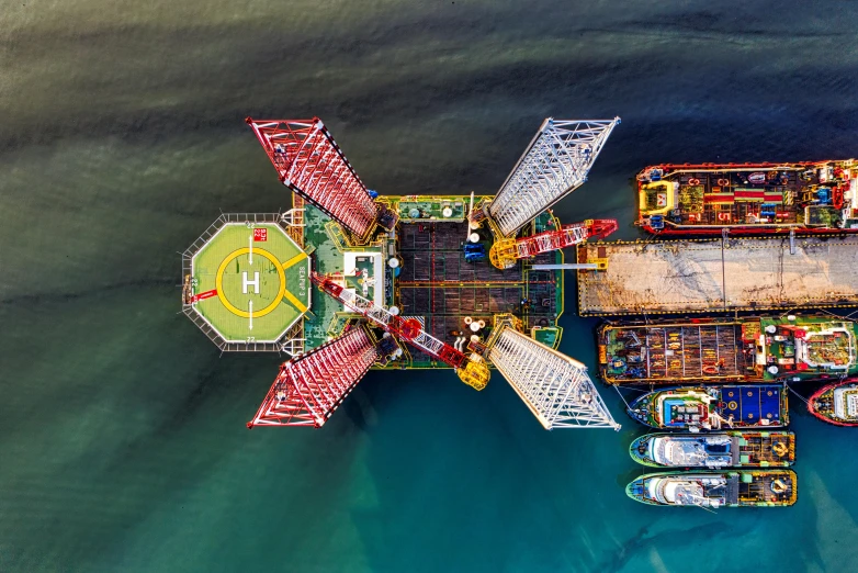 an aerial view of an oil platform in the middle of the ocean, by Sebastian Spreng, pexels contest winner, brightly coloured, shipping docks, three masts, kerem beyit