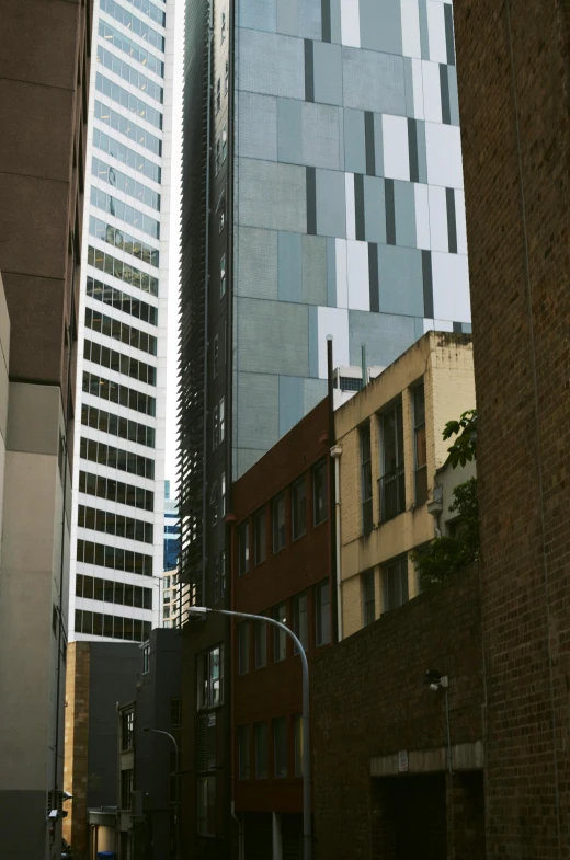 a city street with tall buildings in the background, inspired by Thomas Struth, modernism, in chippendale sydney, close up shot from the side, buildings made out of glass, portrait of tall