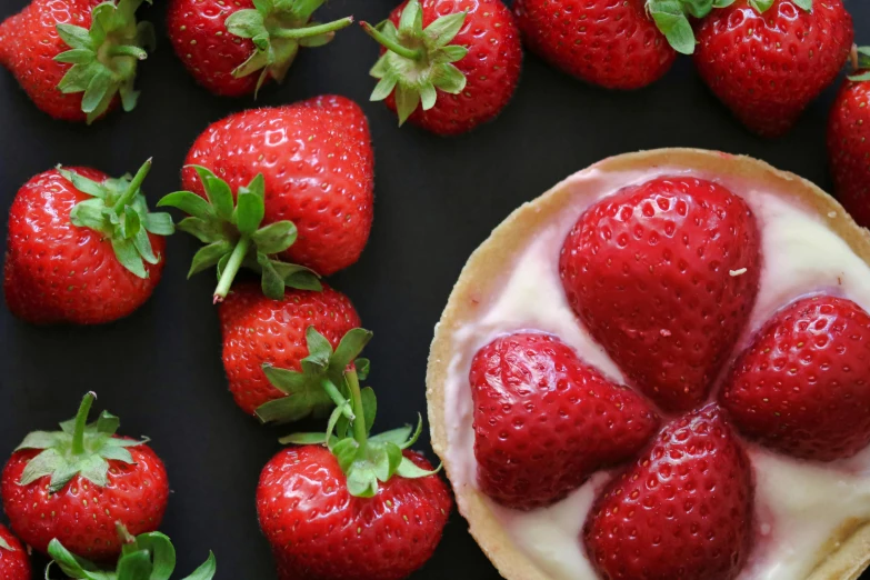 a close up of a tart with strawberries on a table, by Sylvia Wishart, pexels contest winner, photorealism, creamy skin, on a black background, 🎀 🗡 🍓 🧚, istockphoto