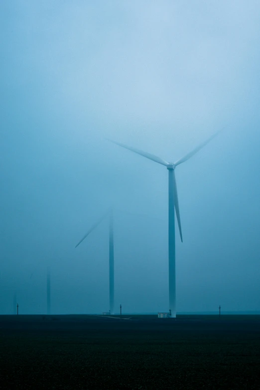 a group of wind turbines in a foggy field, by Jan Tengnagel, minimalism, blue, dutch