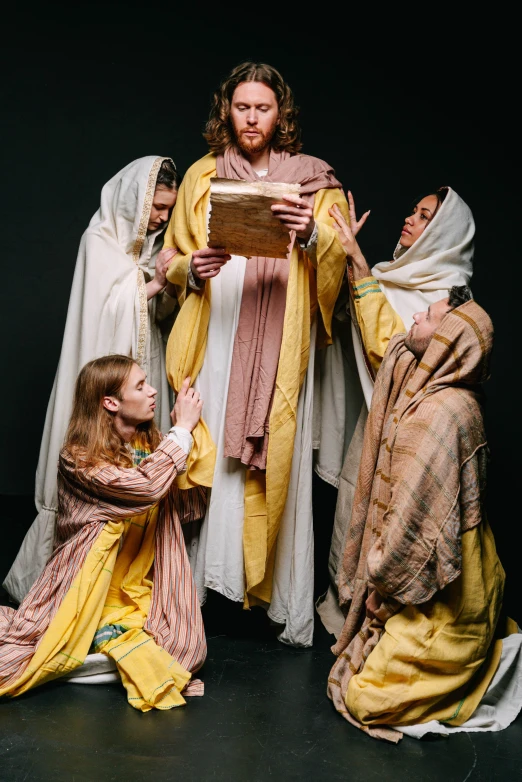 a group of people dressed in biblical clothing, by Everett Warner, trending on unsplash, studio lit, show, female, indoor scene