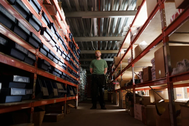 a man standing in a warehouse filled with boxes, industrial lighting, avatar image, liam brazier, store