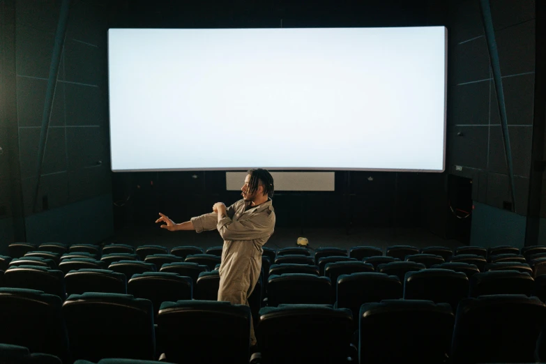 a man that is standing in front of a screen, pexels, video art, theatre equipment, movie scene, adult, press shot