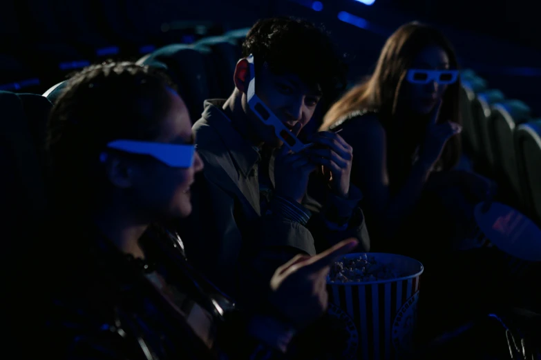 a group of people watching a movie in 3d glasses, a hologram, pexels, holography, extremely moody blue lighting, movie still of the alien girl, eating, raphael personnaz