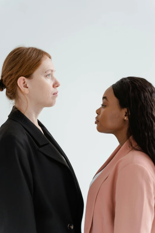 a couple of women standing next to each other, trending on unsplash, realism, realistic », hr ginger, facing each other, mixed race