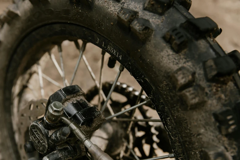 a close up of a tire on a dirt bike, unsplash, photorealism, digital image, spare parts, highdetailed, [ cinematic