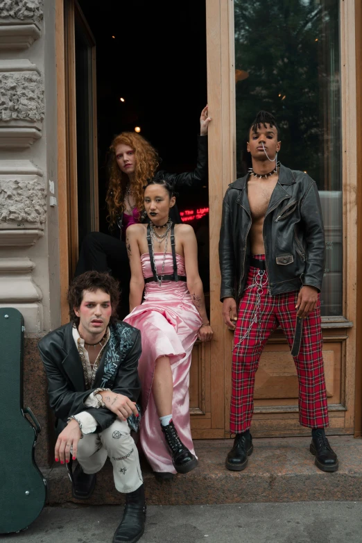 a group of people sitting on the steps of a building, an album cover, inspired by Nan Goldin, renaissance, dressed in punk clothing, met gala, [ theatrical ], ( ( theatrical ) )