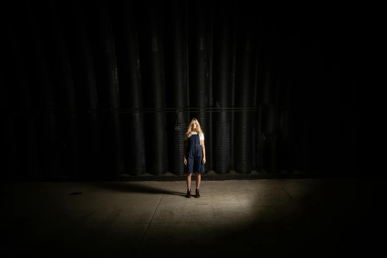 a woman standing alone in a dark room, unsplash, light and space, in warehouse, large scale photo, teenage girl, portrait no. 1