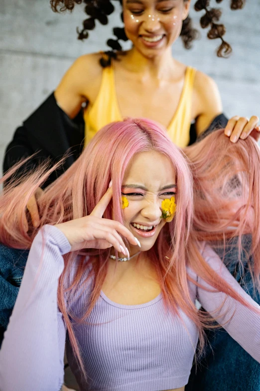 a woman with pink hair cutting another woman's hair, a colorized photo, trending on pexels, perky woman made of petals, long yellow hair, happy face, photograph of three ravers