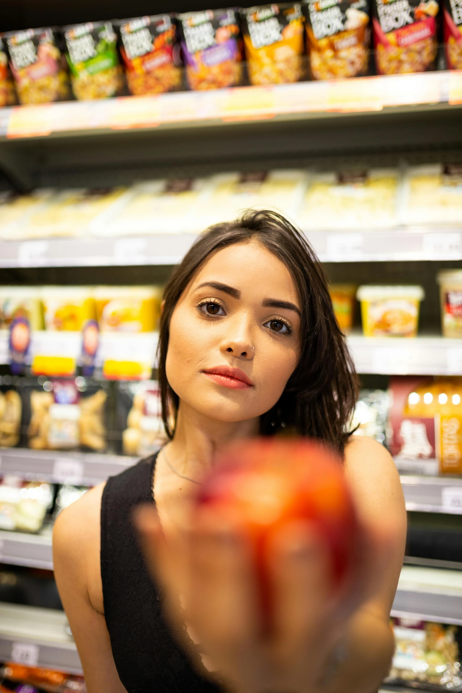 a woman holding an apple in a grocery store, pexels contest winner, realism, portrait of ana de armas, serious focussed look, lucy hale, taken in the late 2010s