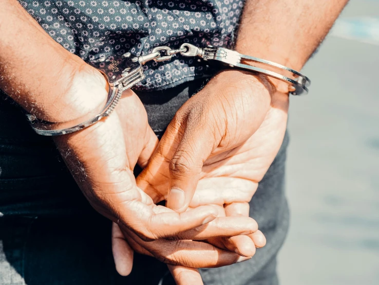 a close up of a person holding a pair of handcuffs, trending on pexels, wearing steel collar, arrested, full colour, multiple stories