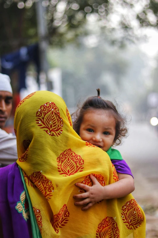 a woman carrying a child on her back, head scarf, air pollution, square, multiple stories